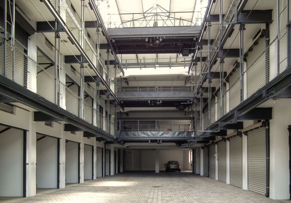 Blick in ein mehrgeschossiges Parkhaus mit Einzelgaragen zu beiden Seiten eines Mittelgangs